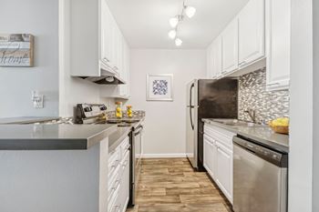 A kitchen with white cabinets and a tile backsplash.